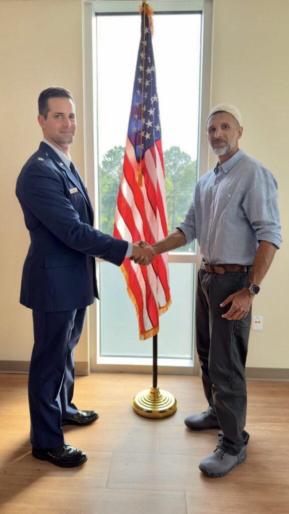 Salman Fidahussein shaking hands with a military officer