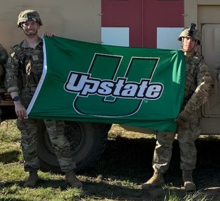 Photo of Clayton Stephens holding a USC Upstate flag