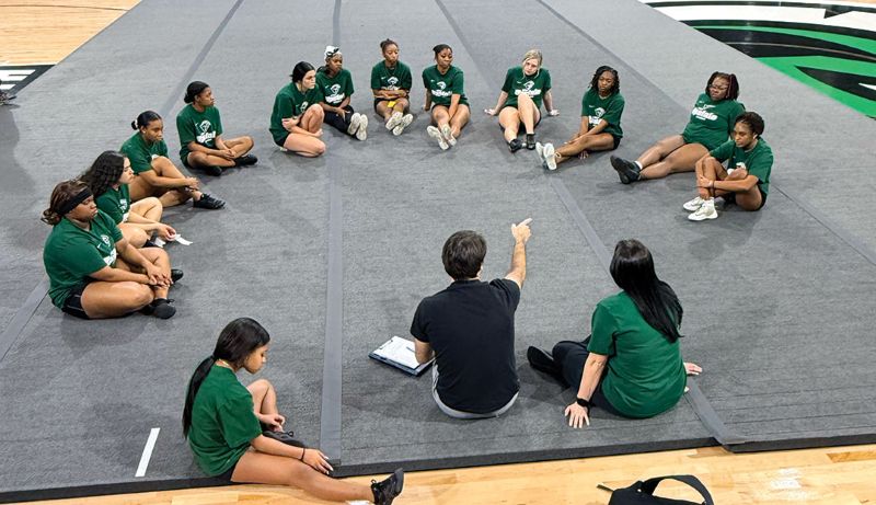 Cheer_Floor Coach Chad Butler talks to the cheer team after practice.